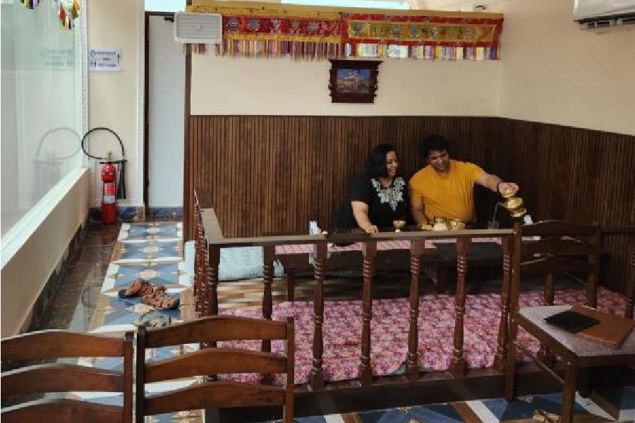 A couple sits on floor to eat in traditional Nepalese style