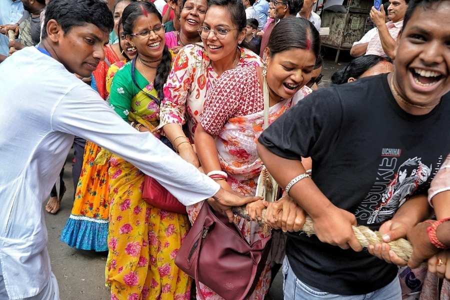 People jostle to get a hold of the chariot’s rope 