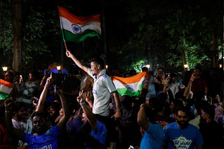 People celebrate after India won the ICC Trophy after defeating the Kiwis in the finals, on a street in Mumbai