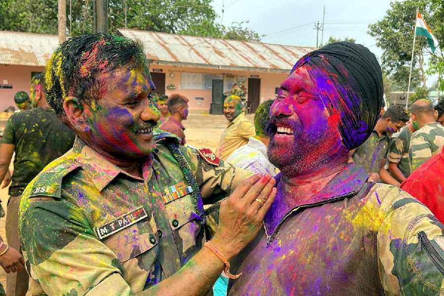 BSF personnel celebrate Holi, the festival of colors, at a border outpost in Lankamura on the outskirts of Agartala, Friday, March 14, 2025. (PTI)