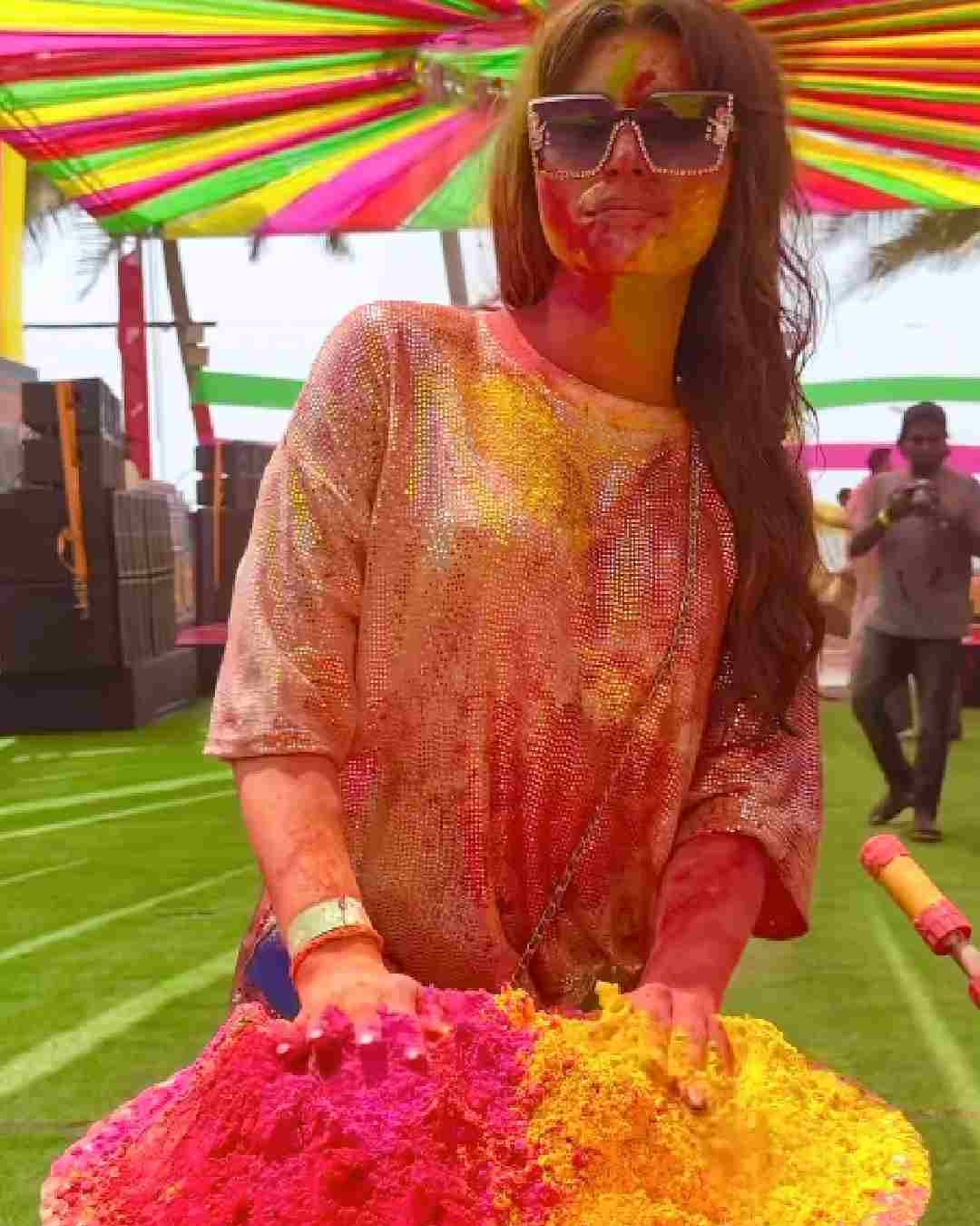Dressed in a shimmery top and stylish sunglasses, Urvashi Rautela posed with a tray of pink and yellow gulaal.