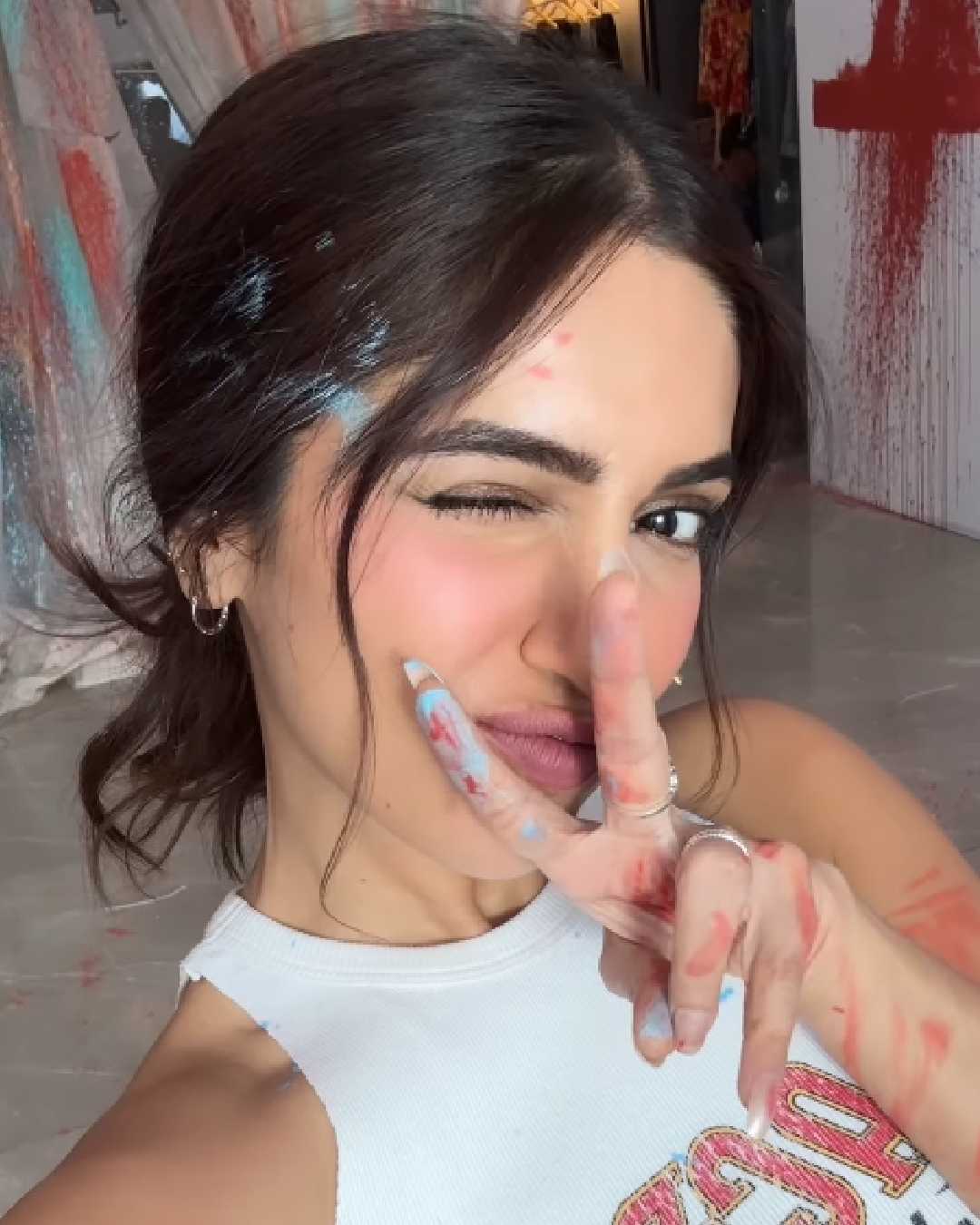 Bhumi Pednekar flashed a victory sign as she clicked a selfie on Holi. With her hair tied up in a messy bun and a white t-shirt splattered with colours, she embodied the carefree joy of the festival. 