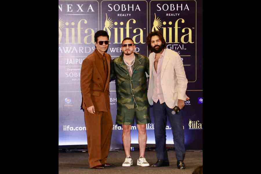 IIFA Awards 2025 hosts Karan Johar and Kartik Aaryan flank mixed martial artist and professional boxer Anthony Pettis at the press conference in Jaipur