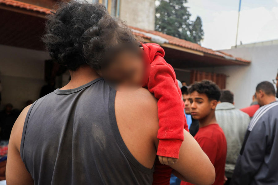 A mourner carries the body of a Palestinian child killed in an Israeli strike, according to medics, at a hospital in Gaza City.