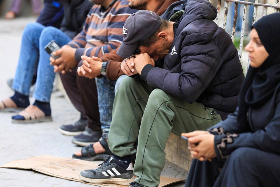 A mourner reacts as people gather near the bodies of Palestinians killed in Israeli strikes, at a hospital in Gaza City.