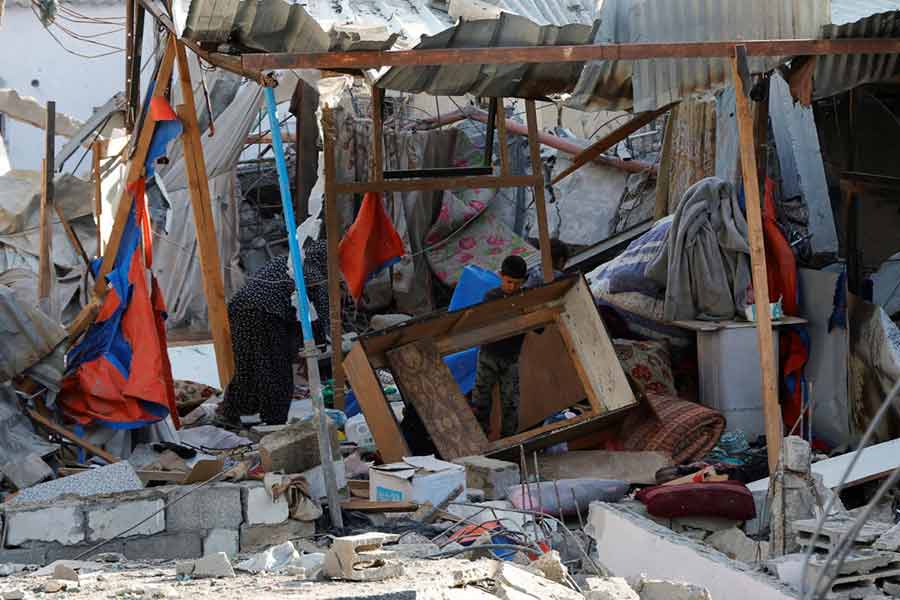 Palestinians inspect the site of an Israeli strike on a house, in Khan Younis in the southern Gaza Strip.