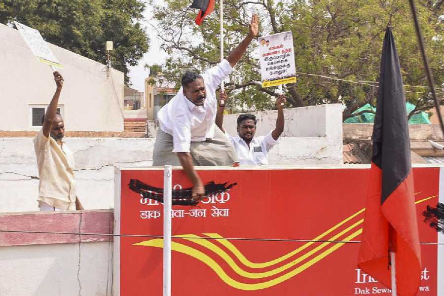 DMK workers paint over the Hindi name board of a post office.