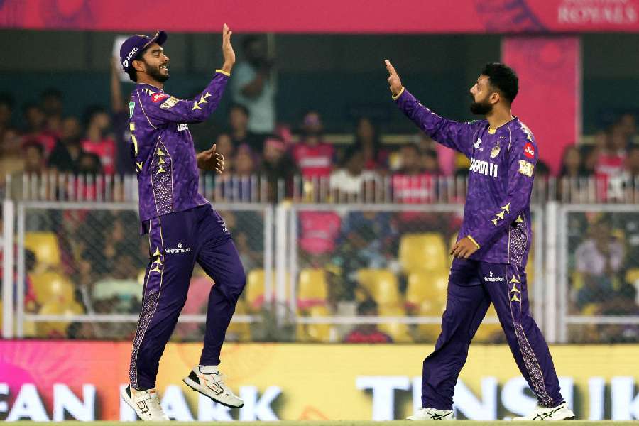 Kolkata Knight Riders' Varun Chakravarthy celebrates with Venkatesh Iyer after taking the wicket of Rajasthan Royals' Wanindu Hasaranga, caught out by Ajinkya Rahane