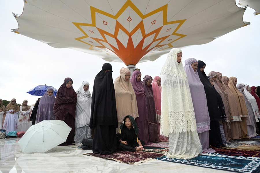 A boy looks on as Muslim women attend mass prayers at Baiturrahman mosque during Eid al-Fitr, marking the end of the holy fasting month of Ramadan in Banda Aceh, Indonesia.
