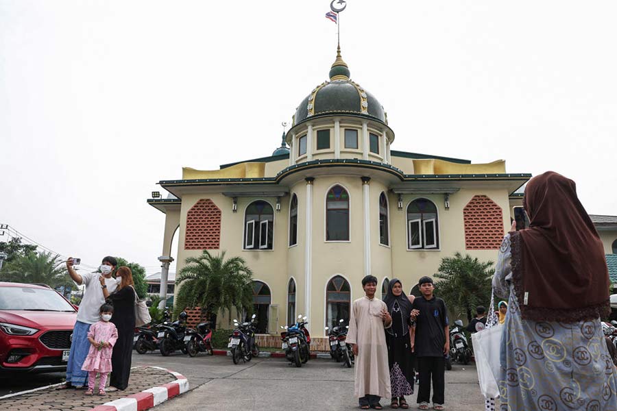 Muslims take pictures outside a mosque after a mass prayer during Eid al-Fitr, marking the end of the holy fasting month of Ramadan, in Bangkok, Thailand.