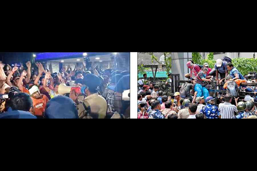 Police ask protesters to calm down at Bikash Bhavan on Thursday evening. Protesters climb a gate of Bikash Bhavan during the gherao on Thursday afternoon