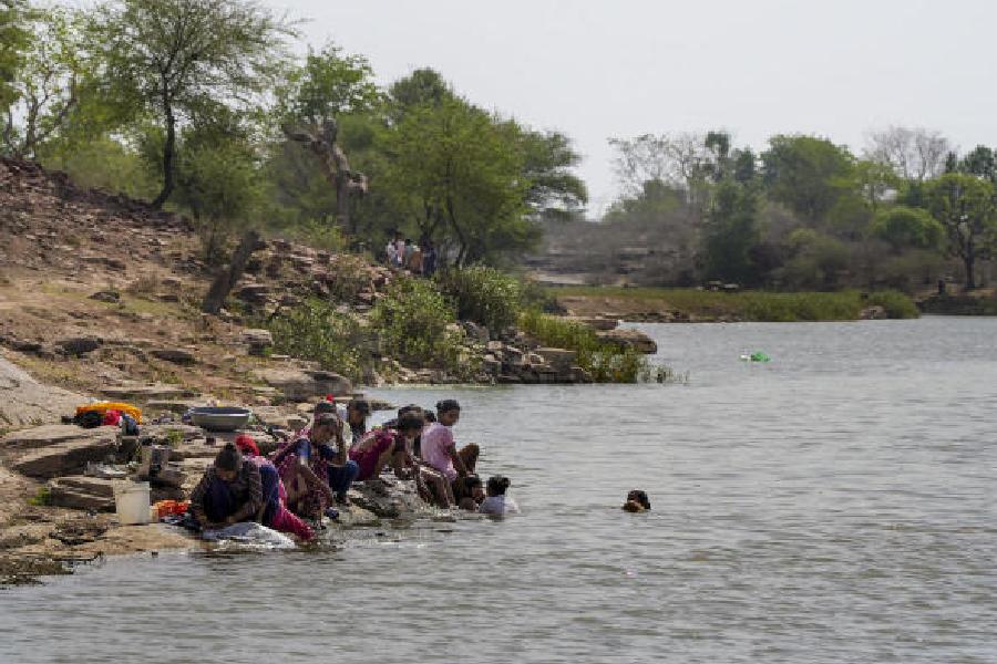 Women bathe and wash clothes on the banks of the once-parched Serni river