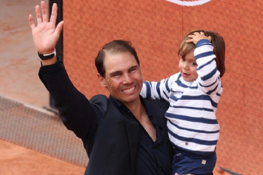 Rafael Nadal takes a bow, with his son in his arms, at the Court PhilippeChatrier during a ceremony held in his honour on Day One of the 2025 French Open in Paris