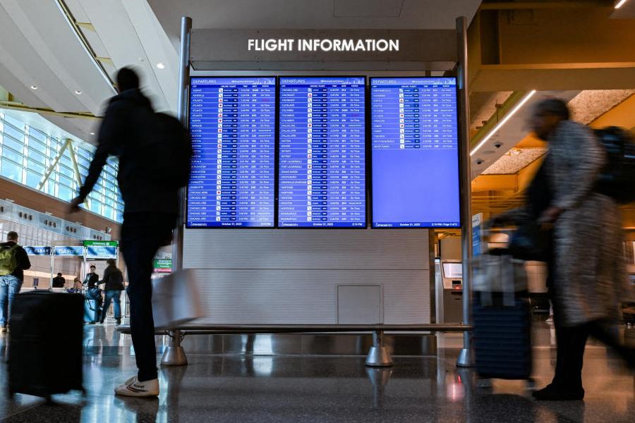 Travelers walk through the airport as the U.S. government shutdown enters 31st day in Washington, DC, U.S., October 31, 2025.