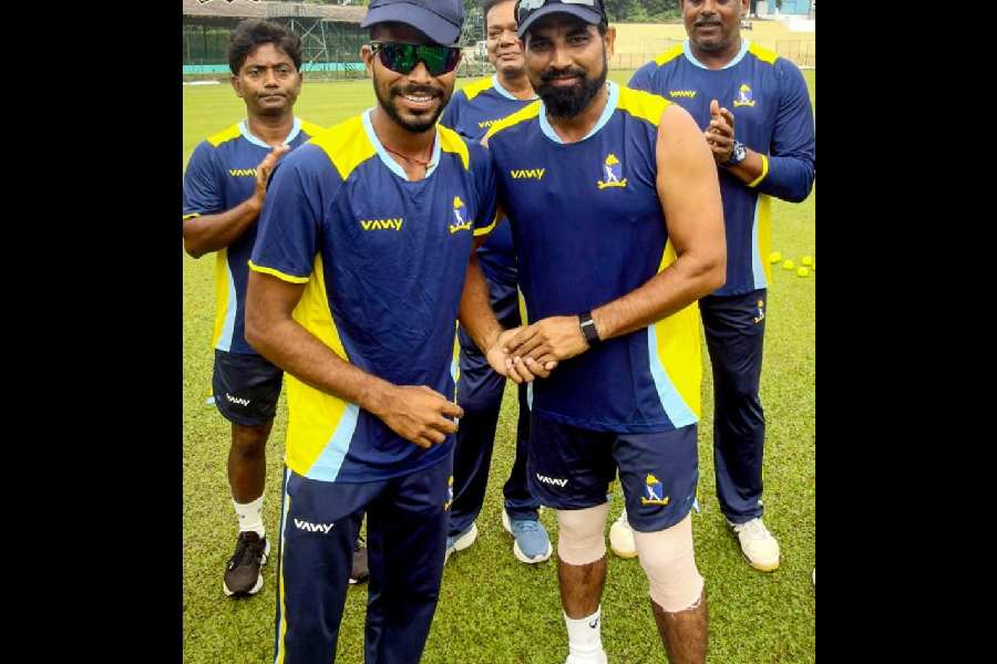 Bengal spinner Rahul Prasad, who made his Ranji debut on Saturday, receives his cap from Mohammed Shami in Agartala.