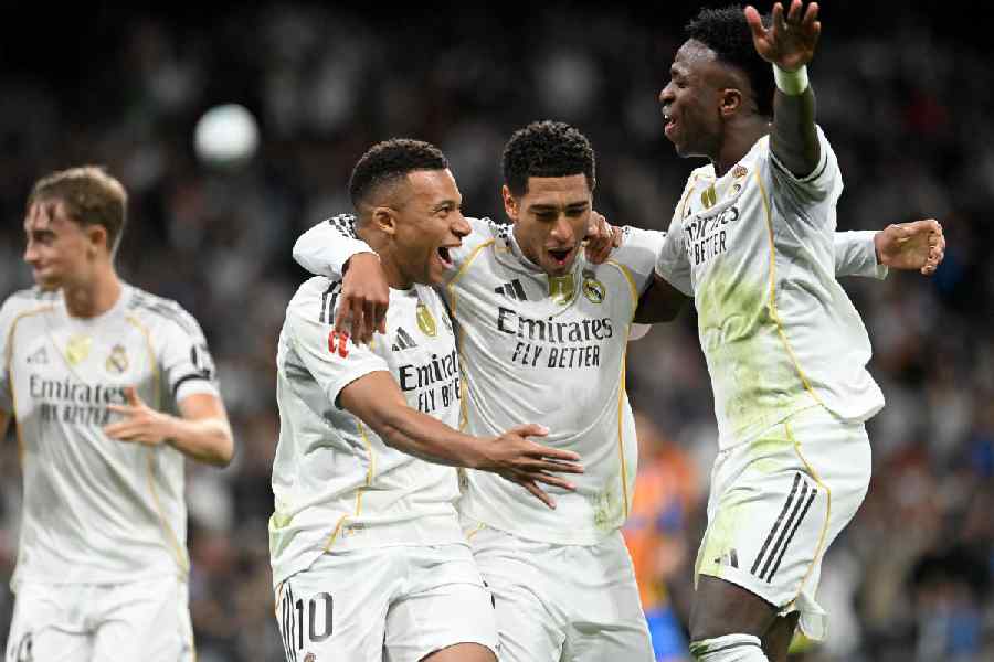 Real Madrid's Kylian Mbappe celebrates scoring their first goal with Jude Bellingham and Vinicius Junior.
