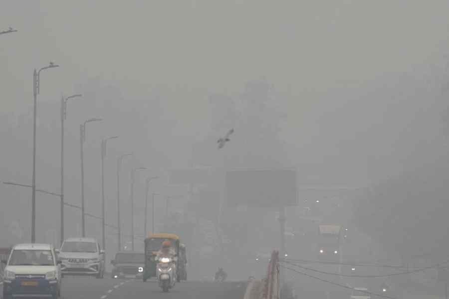 People commute as a layer of smog engulfs the city after deterioration in air quality in Delhi-NCR, in New Delhi, Thursday, Oct. 30, 2025.