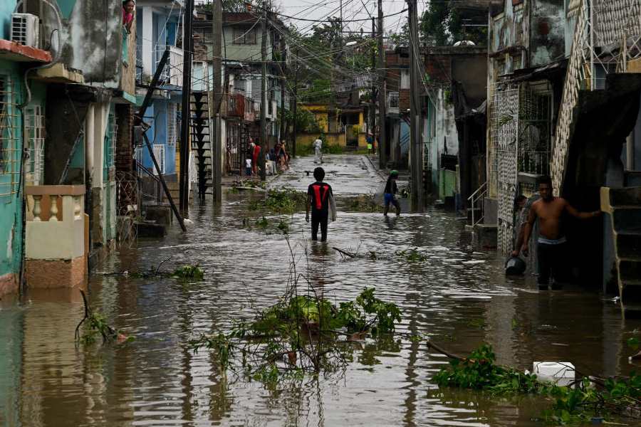 Residents stand in a flooded street, in the aftermath of Hurricane Melissa, in Santiago, Cuba, October 29, 2025