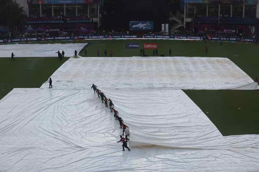 Ground staff remove the covers from the pitch.