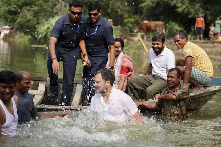 Rahul Gandhi interacts with fishermen after jumping into the pond in Begusarai on Sunday.