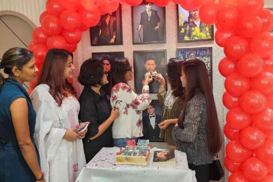 Members of The King's Club offers a piece of the freshly cut cake to a picture of Shah Rukh Khan on his 60th birthday in a Howrah salon. Picture by Sudeshna Banerjee