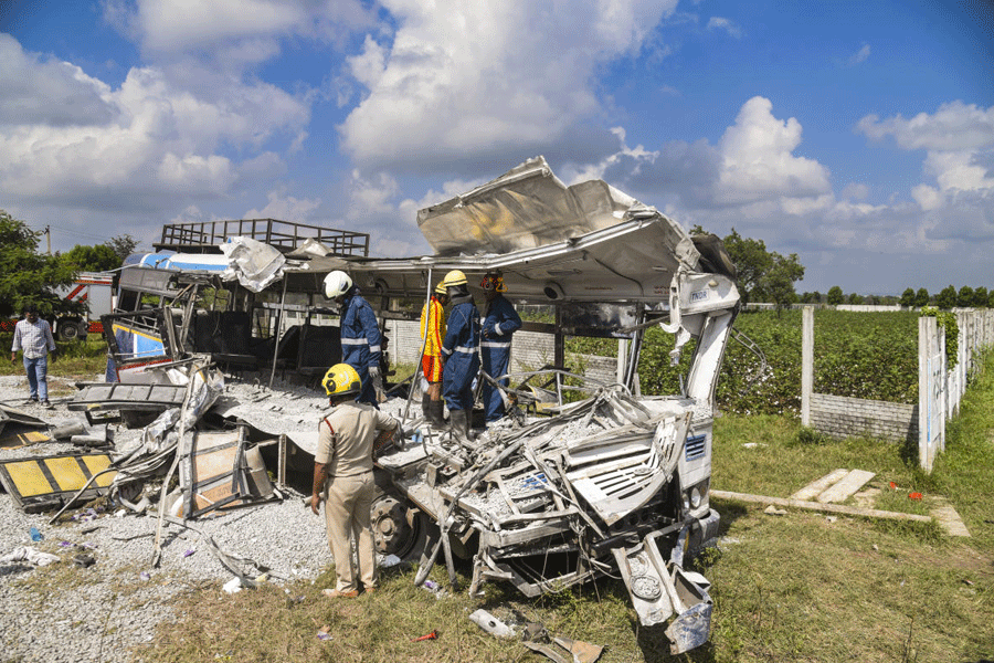 Police and firefighters inspect the wrecked remains of a public transport bus after a head-on collision with a tipper lorry carrying gravel, in Rangareddy district, Telangana, Monday, Nov. 3, 2025.