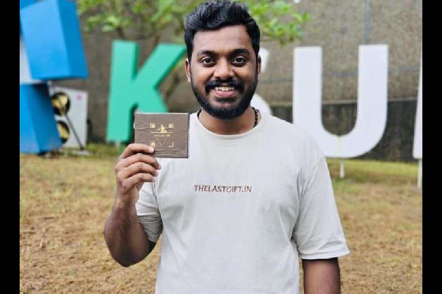 Stebin Chackalackal Xavier shows a metal plate engraved with a QR code