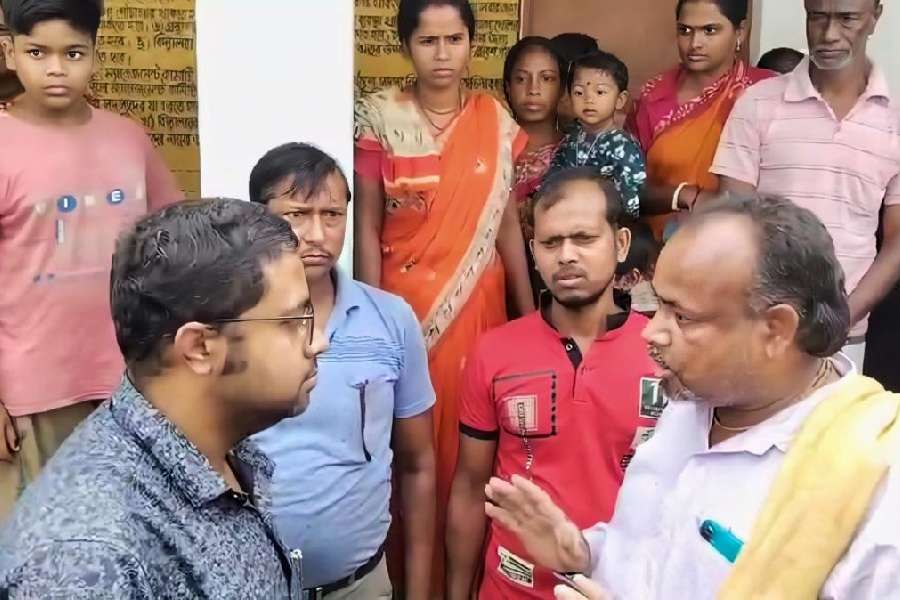 Joint BDO Mayukh Banerjee (left) requests villagers to release the teachers locked inside the school premises in Gaighata, North 24-Parganas, so that they can work as BLOs. 
