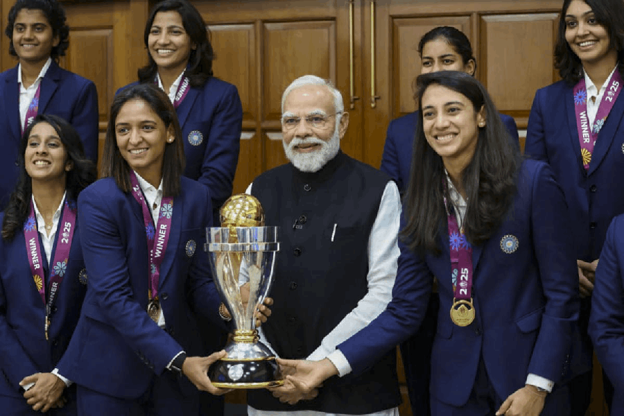 In this image received on Nov. 5, 2025, Prime Minister Narendra Modi poses with the Indian Women’s World Cup-winning team and the trophy at his residence, in New Delhi.