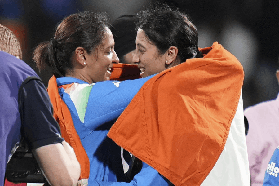 India’s captain Harmanpreet Kaur, left, and vice captain Smriti Mandhana hold the Indian tricolour as they celebrate after winning the ICC Women's World Cup final ODI cricket match between India Women and South Africa Women, at the DY Patil Stadium, in Navi Mumbai, Sunday, Nov. 2, 2025.