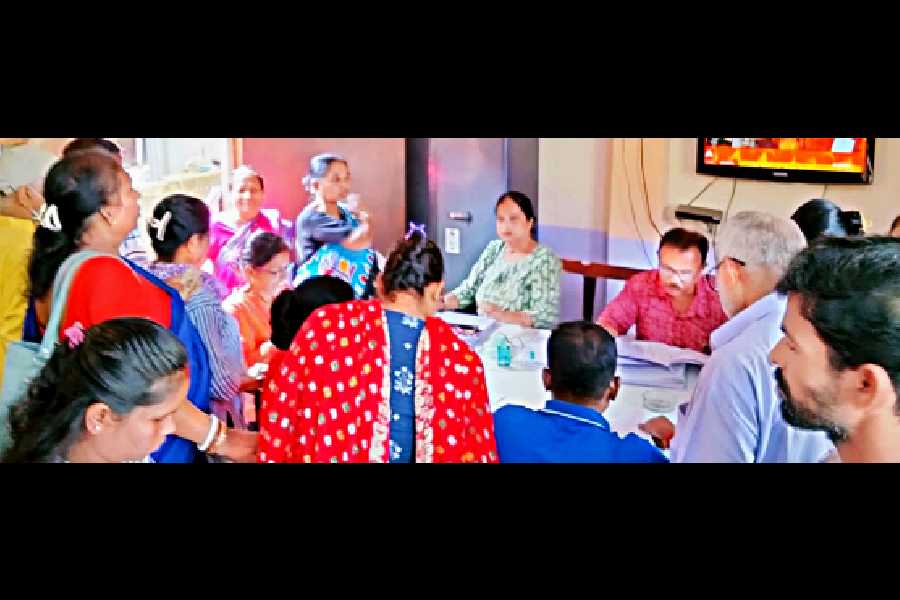 Residents crowd around an SIR help desk set up by a political party in Jadavpur