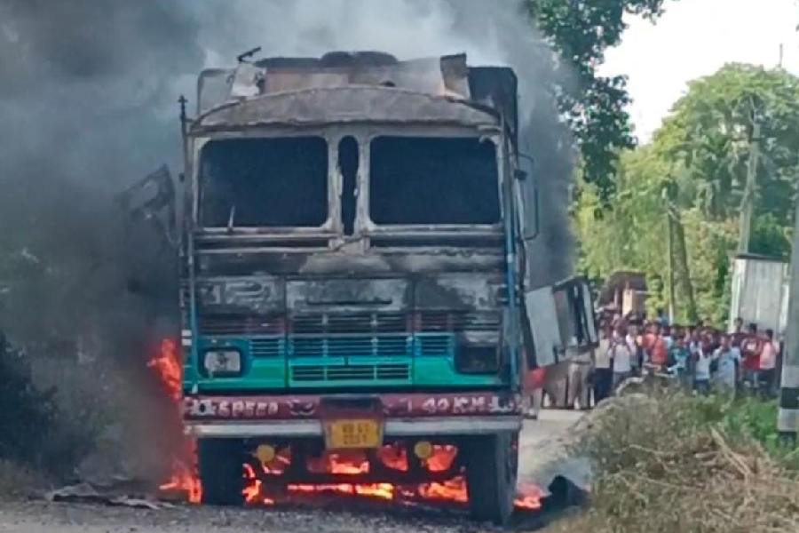 The truck set ablaze after the accident at Kumarganj in South Dinajpur on Wednesday
