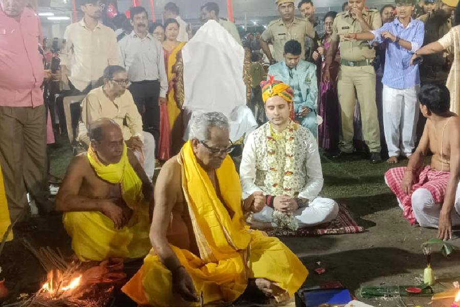 Raju Mishra, the district magistrate (seated, in traditional attire and turban) at the puja performed to mark the opening of Raas Utsav at the Madanmohan Temple Complex in Cooch Behar on Wednesday. 