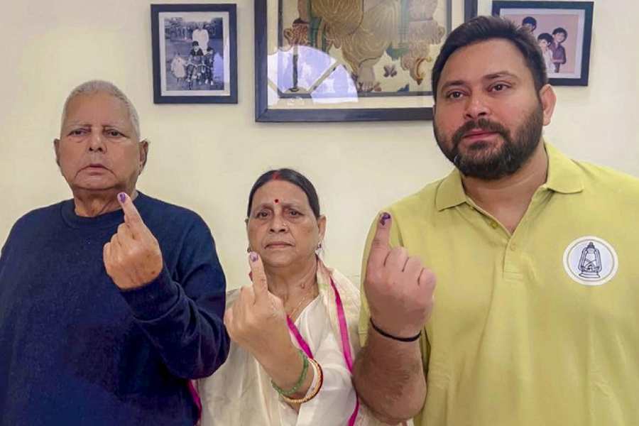 Lalu Prasad, wife Rabri Devi and son Tejashwi Yadav show their inked fingers after voting in Patna on Thursday. 