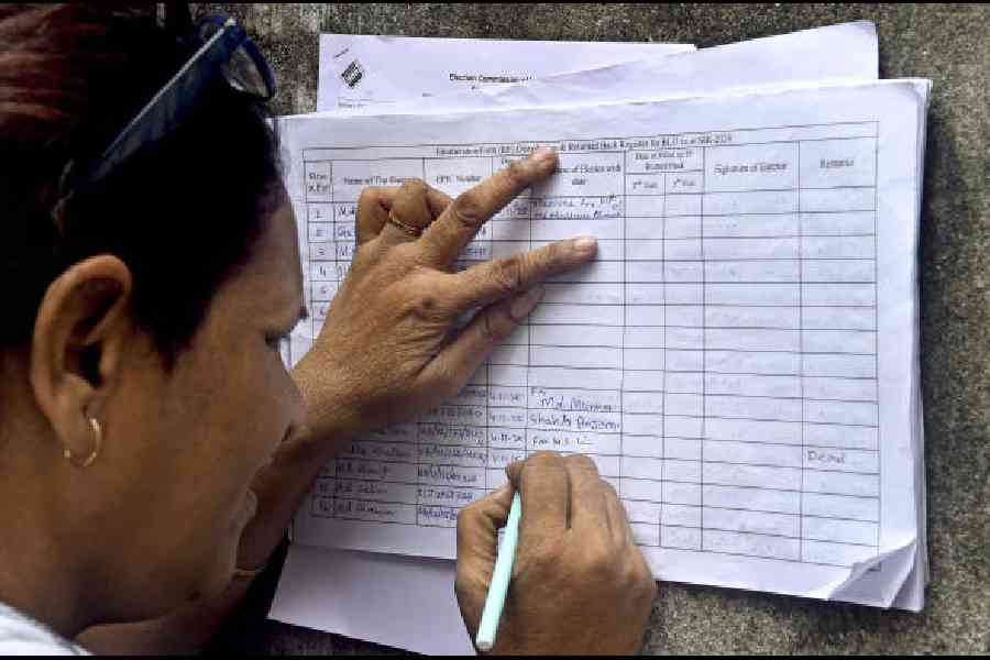 A voter fills her details during door-to-door verification by booth-level officers (BLOs) for the special intensive revision (SIR) of electoral rolls in Calcutta. (PTI)