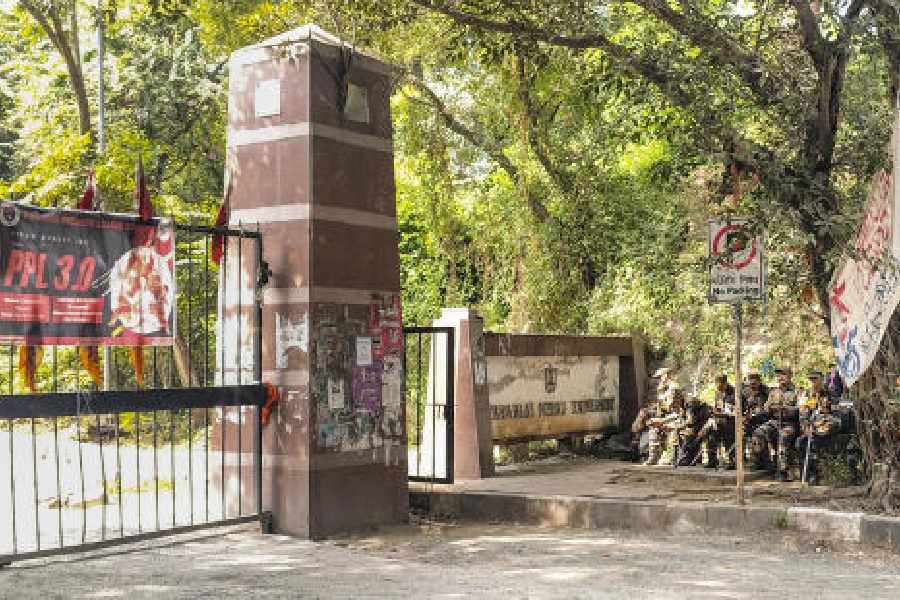 Security personnel sit at the entrance to the Jawaharlal Nehru University (JNU) on the day of JNU Students' Union (JNUSU) elections.