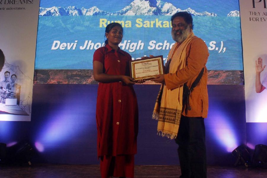 Ruma Sarkar receives the scholarship from Supratim (Raj) Basu on Saturday