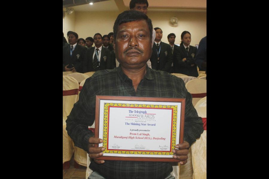 Premlal Singh, an employee of Muraliganj High School, with his award.