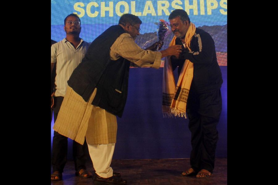 Mrinmoy Ghosh (right) being greeted at the awards function in Siliguri on Saturday.