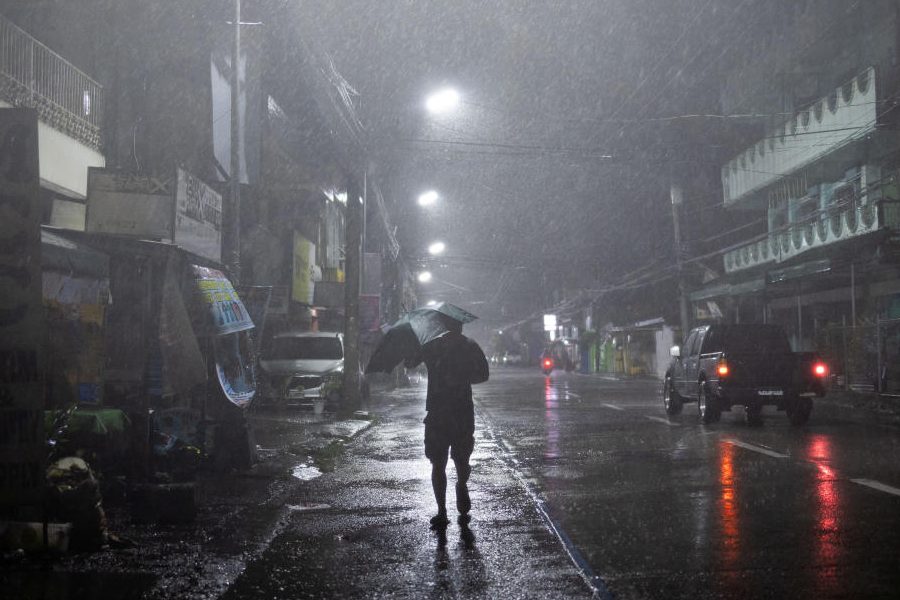 A man walks in the rain with an umbrella as Typhoon Fung-wong approaches, in Cauayan, Isabela, Philippines, November 9, 2025.