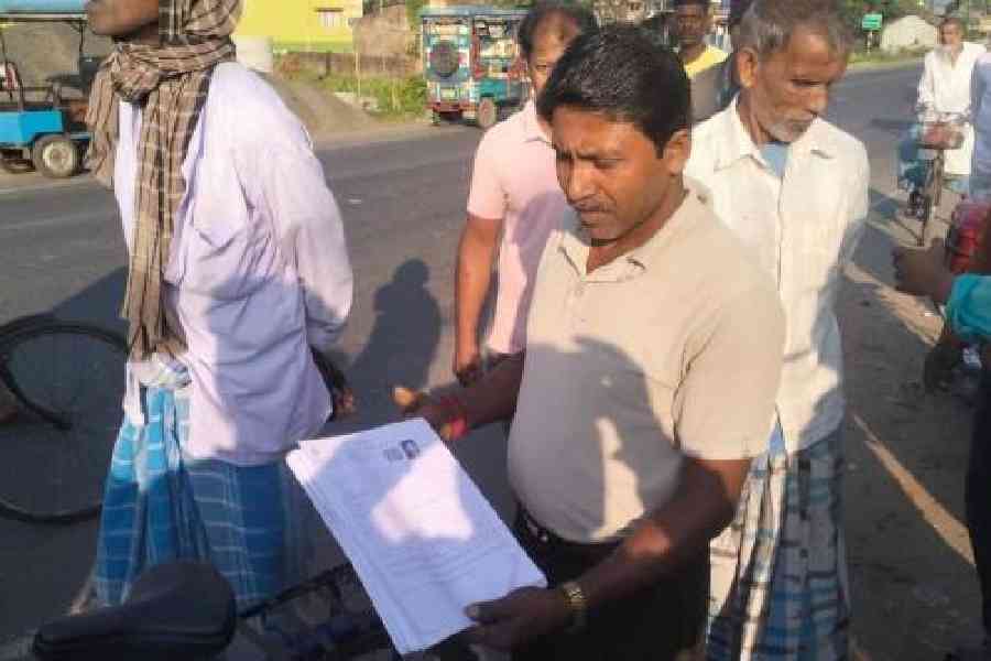 A man shows the 21 enumeration forms from South Dinajpur that were recovered from a road in East Burdwan’s Kalna. Picture by Dip Das