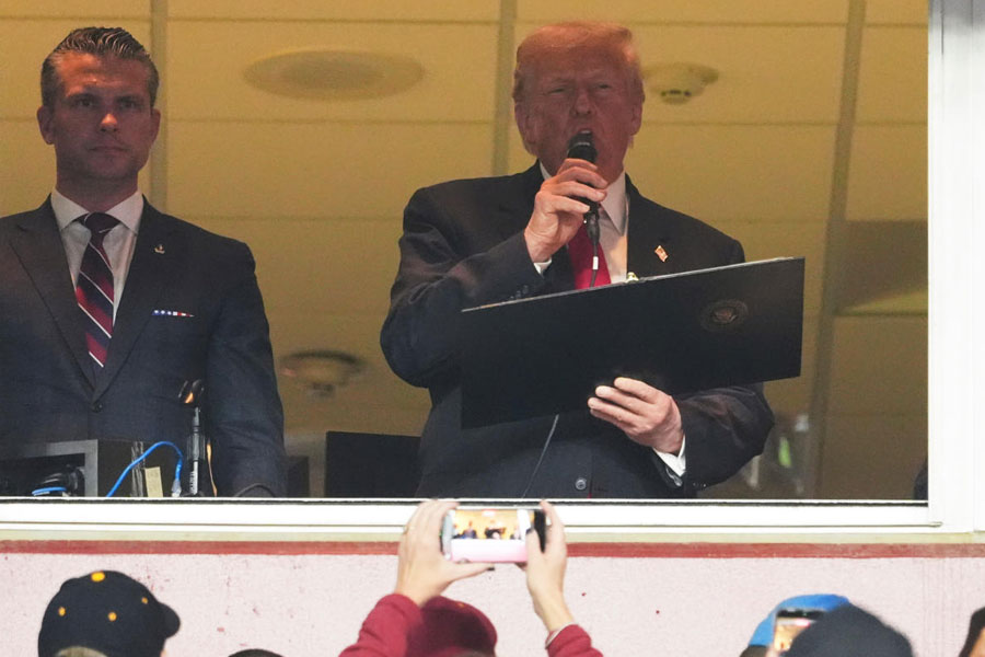 President Donald Trump delivers the Oath of Enlistment alongside Defense Secretary Pete Hegseth, left, during an NFL football game between the Washington Commanders and the Detroit Lions at Northwest Stadium in Landover, Md., Sunday, Nov. 9, 2025.
