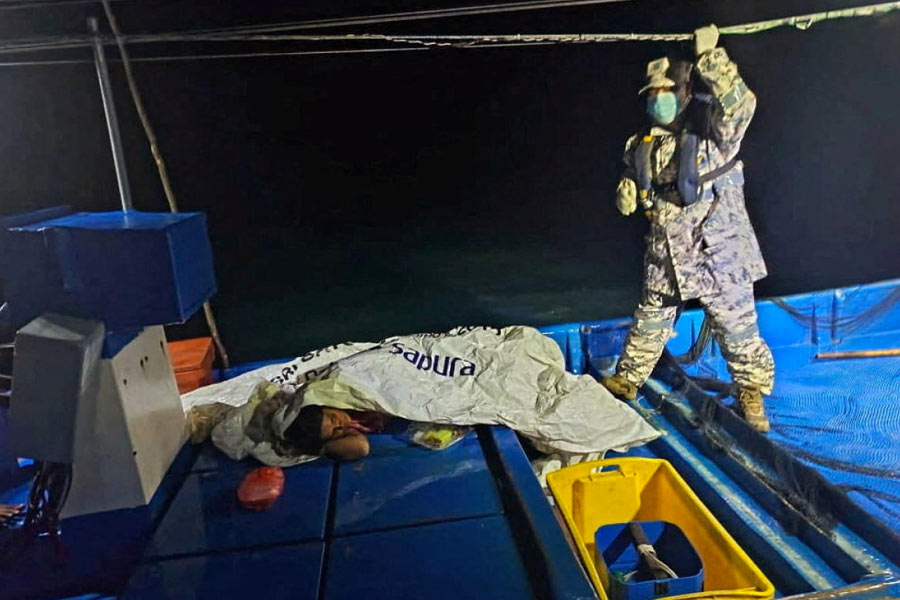 A staff of the Malaysian Maritime Enforcement Agency checks on a survivor who was rescued by a fishing boat's crew after a boat from Buthidaung, Myanmar, sank near the Malaysia–Thailand border, close to Langkawi, Malaysia November 9, 2025.