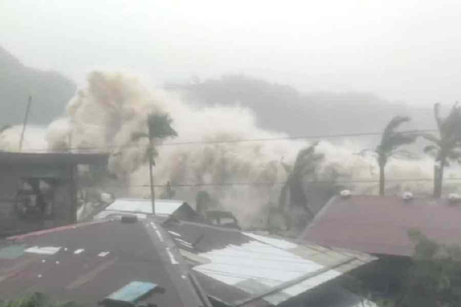 Palm trees and residential rooftops stand as strong waves caused by Super Typhoon Fung-wong crash, in Sicmil, Gigmoto, Catanduanes, Philippines, November 9, 2025, in this screengrab obtained from a social media video.