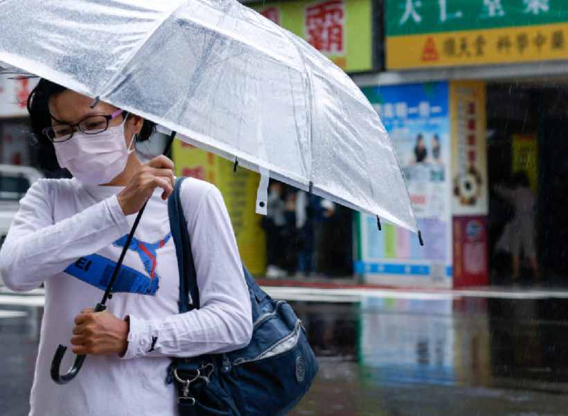 A woman holds her umbrella amidst strong winds and rain as Typhoon Fung-wong approaches, in Taipei