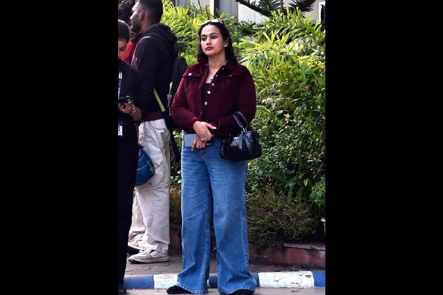 A commuter in woollens waits for a bus near Eden Gardens on Tuesday morning.
