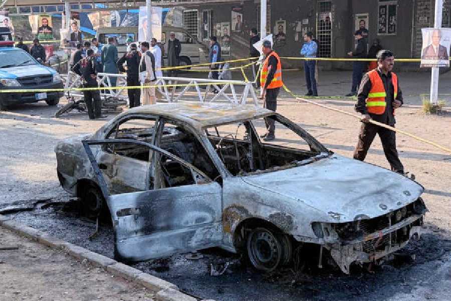A mangled car at the site of the explosion as security officials and rescue workers gather outside the Islamabad court on Tuesday. 