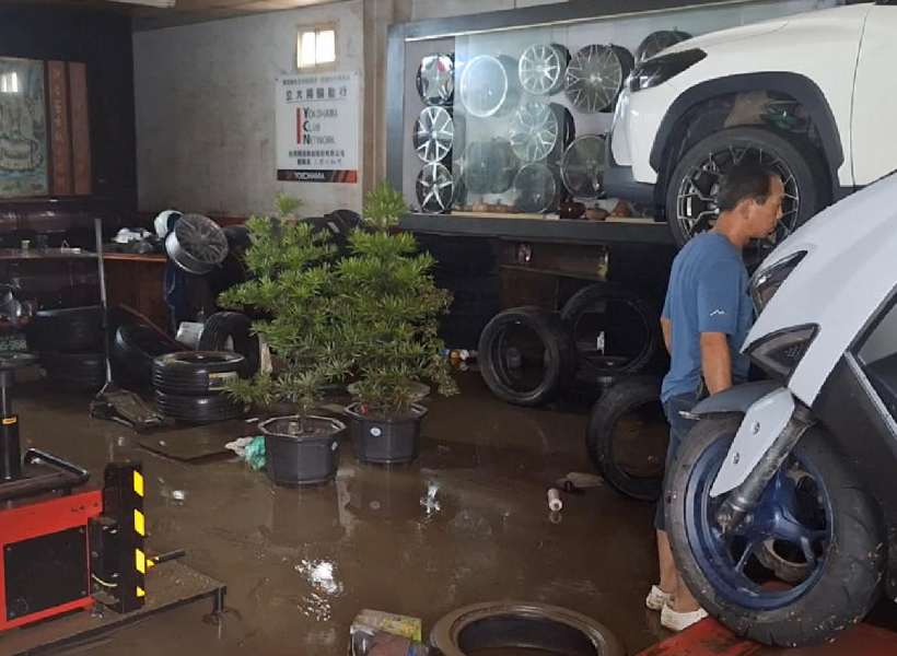 A man stands in a flooded garage in the aftermath of heavy rain due to the arrival of Typhoon Fung-wong in Yilan