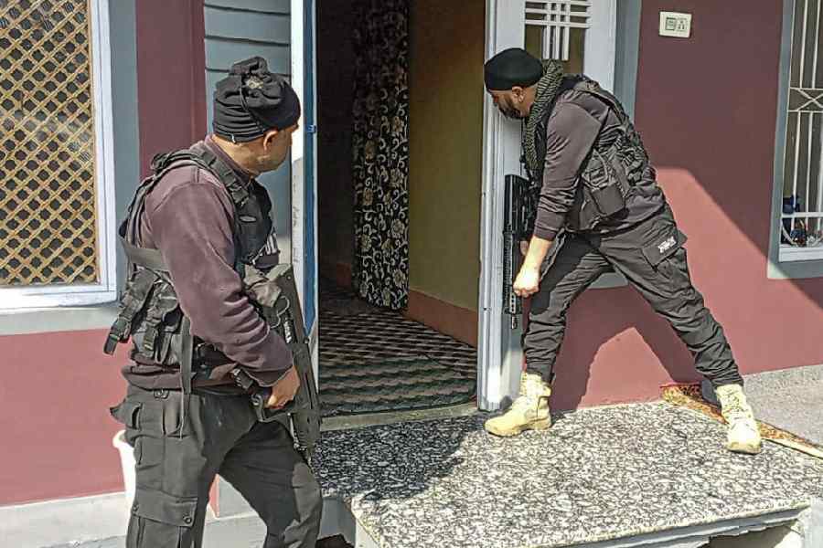 Police personnel raid a house as part of a search operation following the blast near Delhi's Red Fort, in Anantnag, Jammu and Kashmir, Wednesday, Nov. 12, 2025. Armed officers in tactical gear are seen entering a residential premises.