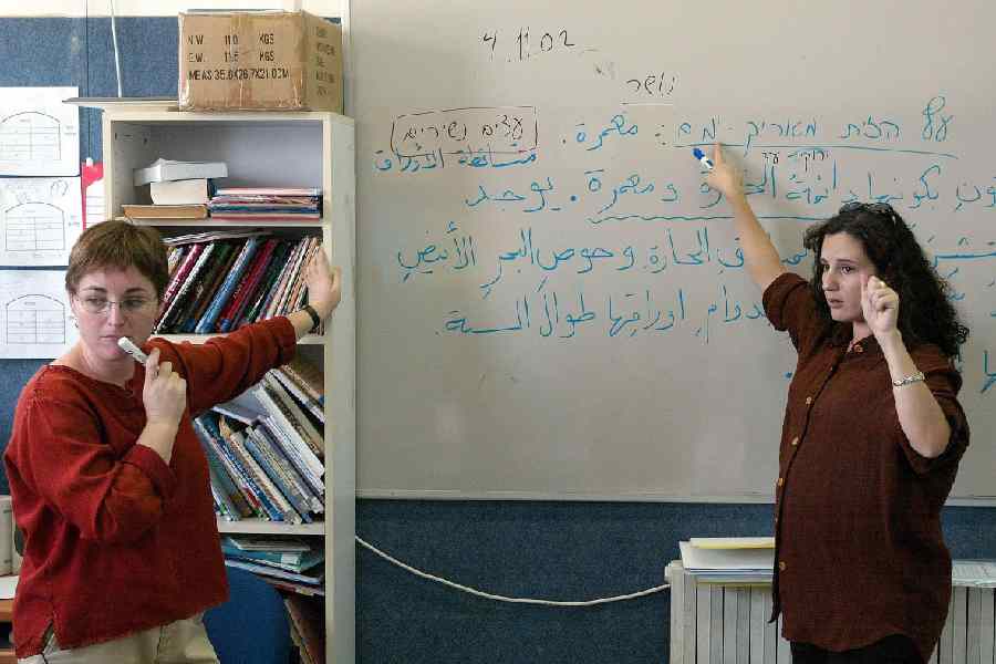 Jewish teacher Ruti Shimron Vadai (left) and her Arab counterpart Ulfat Salman teach language to Class IV pupils at the Bilingual School in Jerusalem.